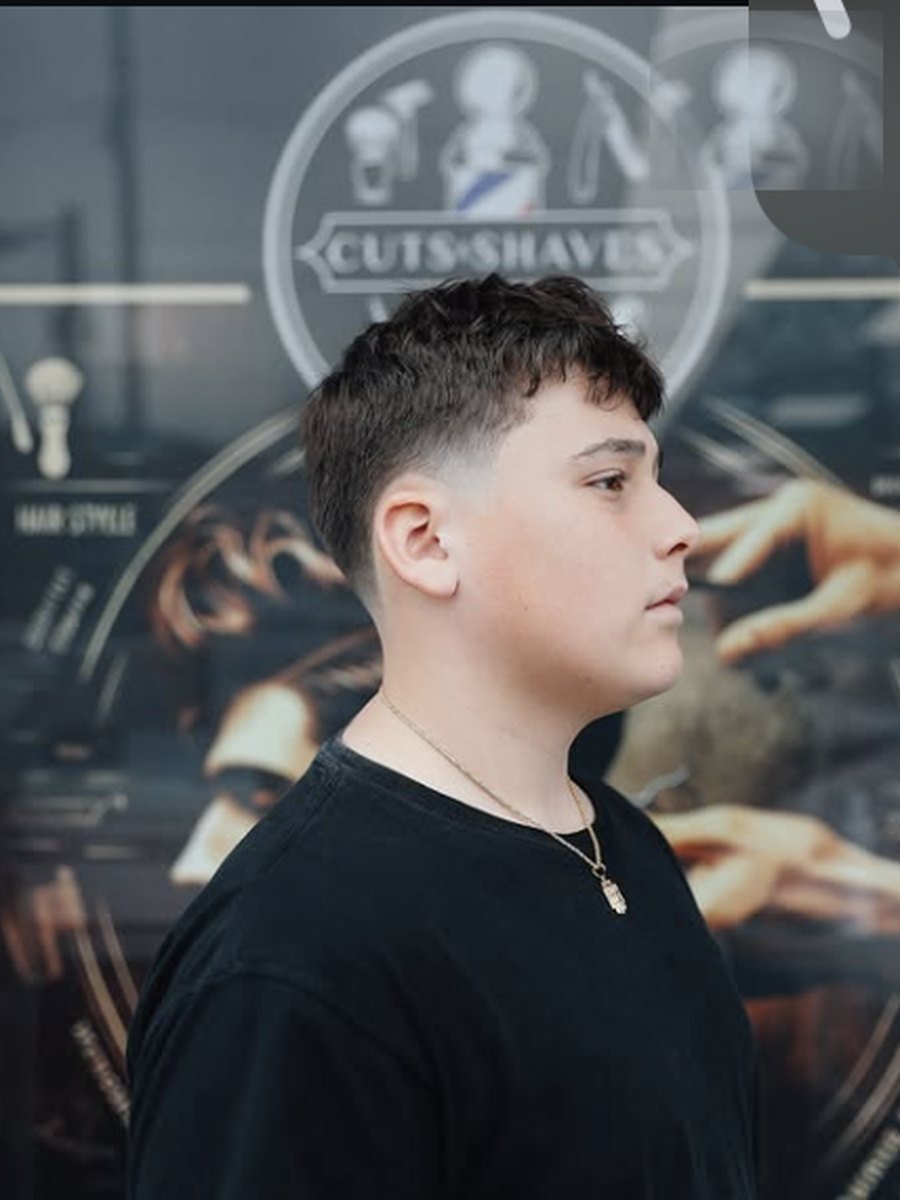 Textured crop with a clean mid fade on a young client at Plaza Barber Shop West Hempstead