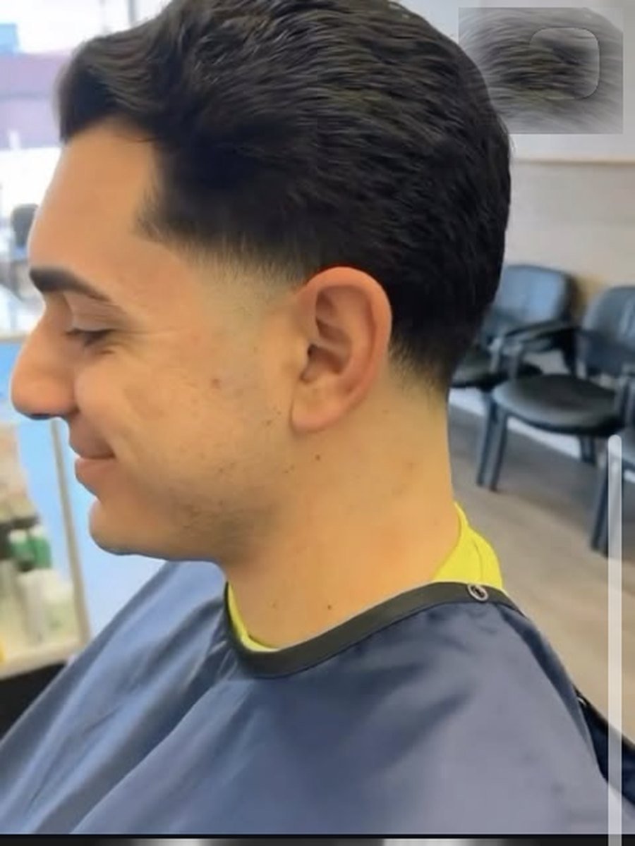 Curly top with a tight fade through the sides at Plaza Barber Shop West Hempstead
