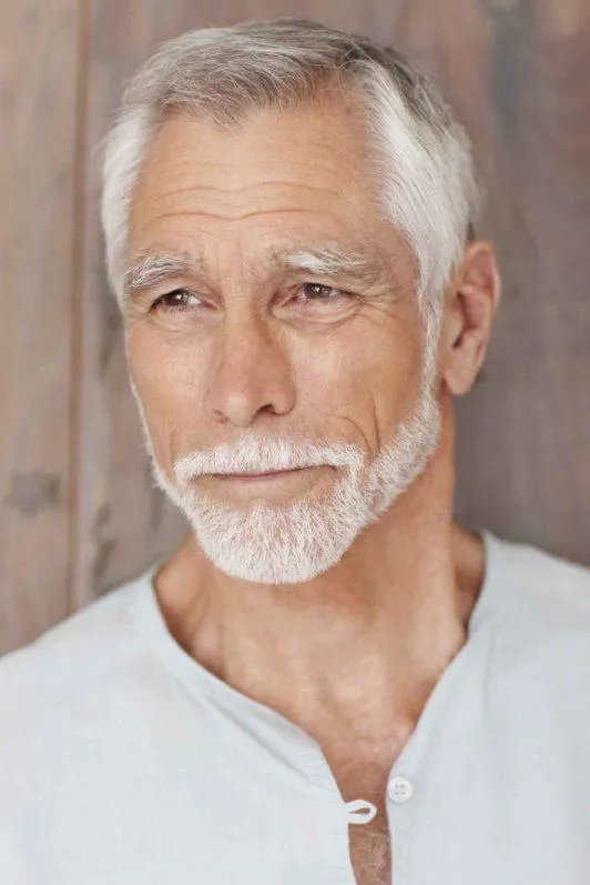 Older gentleman with a neatly kept classic cut and beard