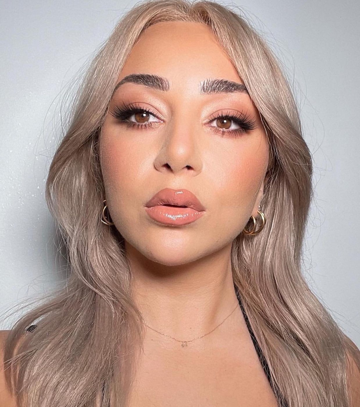 Blonde client with glossy lips and fully shaped brows