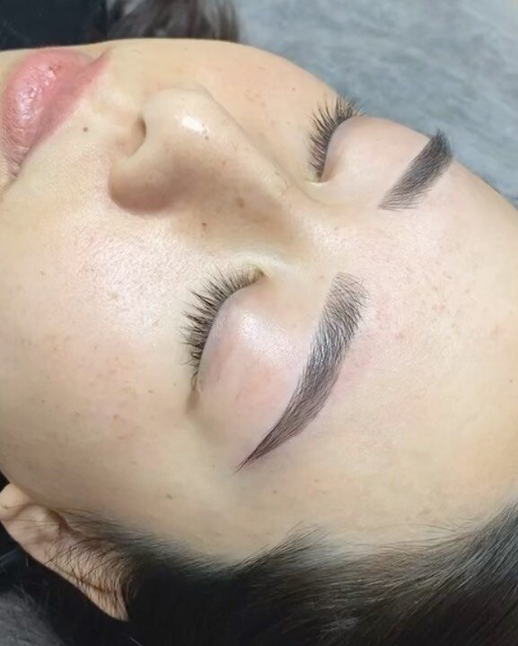 Client reclined at the end of a cosmetic tattoo brow appointment
