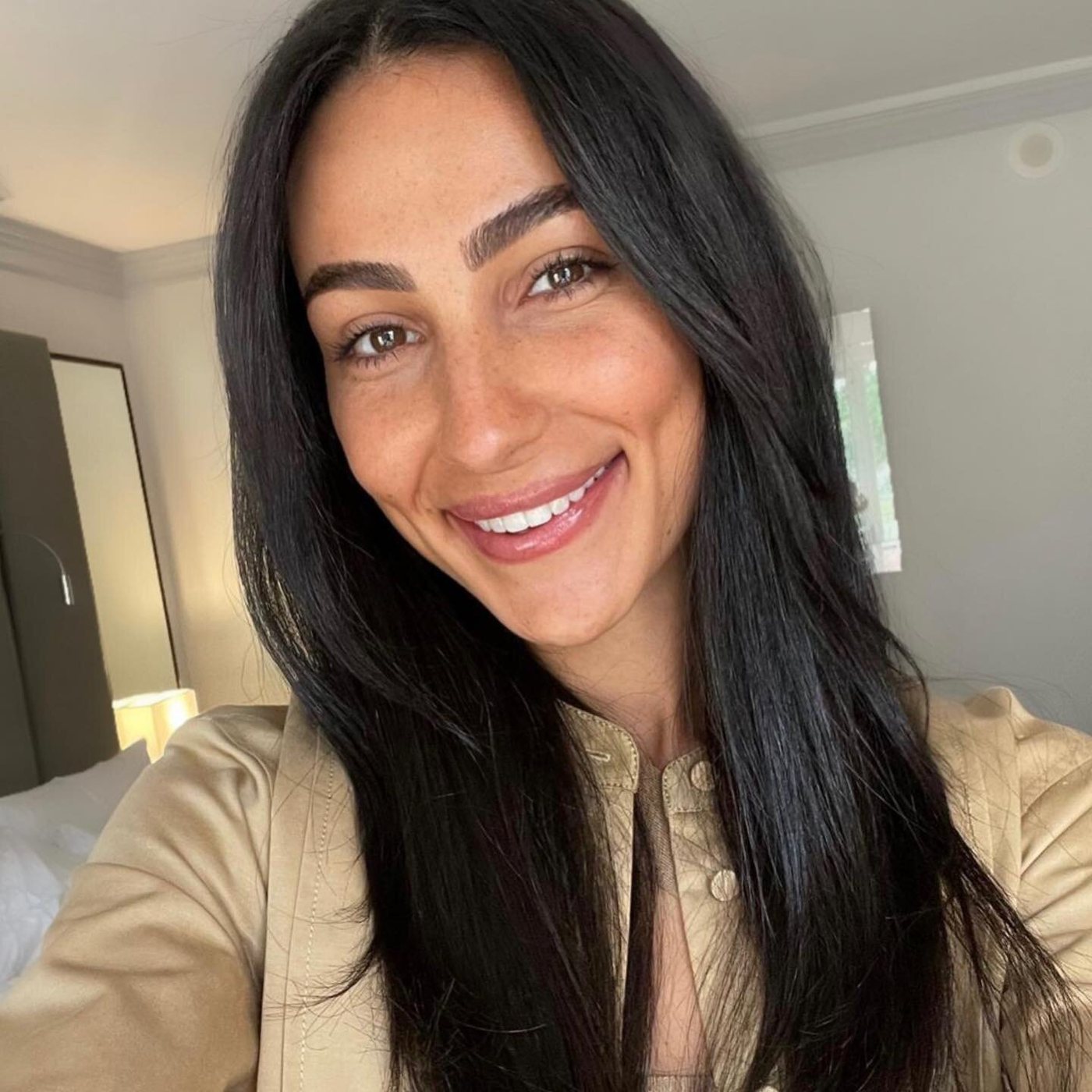 Client with dark hair smiling, wearing natural cosmetic tattoo brows